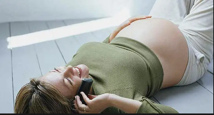 trudnica lezi i prica sa mobilnim telefonom